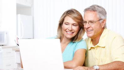 old couple smiling at computer
